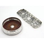 A silver mounted wine coaster, together with a repousse decorated silver tray with scalloped edge.