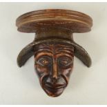 A wall bracket, the reconstituted stone face with planished cast metal hat, height 17.5cm.