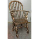 A reproduction child's Windsor armchair, with a spindle filled back on solid seat and turned legs,