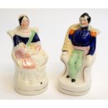 A pair of small Staffordshire figures Victoria and Albert each seated, she has a child on her lap,