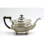 An Edwardian Thomas Hayes half fluted silver teapot with foliate decoration to the rim,