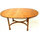 An Ercol Saville oval extending dining table, on turned supports with `X` shaped stretcher,