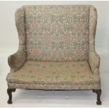 An 18th century style walnut upholstered winged back sofa,