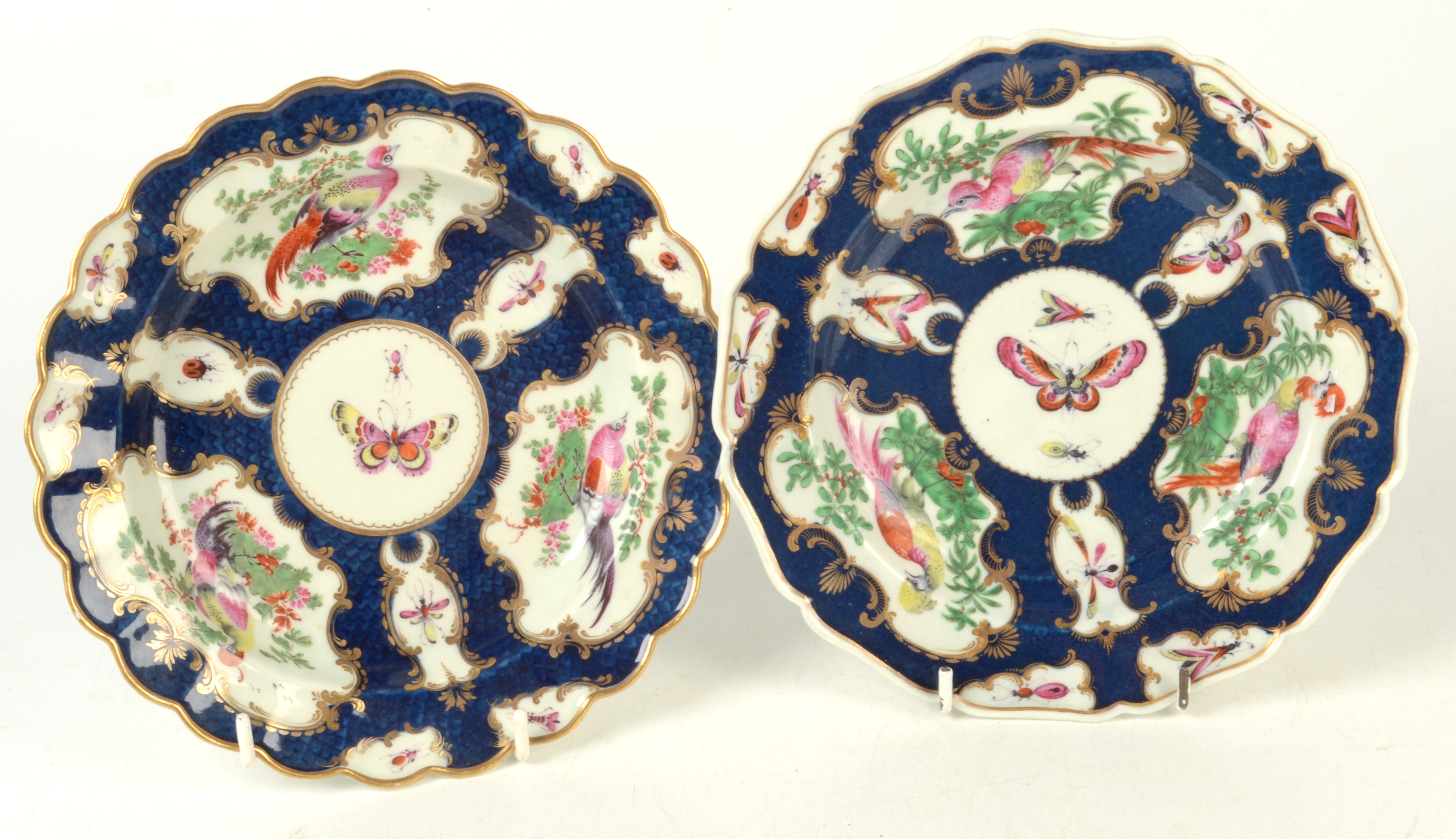 Two 18th century Worcester plates with scale blue ground and three panels of exotic birds,