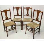 A set of four Arts & Crafts oak dining chairs, each with a shaped vertical heart pierced splat,