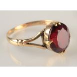 A 9ct gold ring set a red stone.