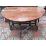 An oak gate leg dining table, substantially 18th century, the open top above a single frieze drawer,