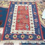 A Turkish kelim rug, the red ground with leaves vines and floweheads, within two borders,