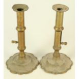 A pair of brass ejector candlesticks, 18th century, each with petal shaped bases, height 20cm.