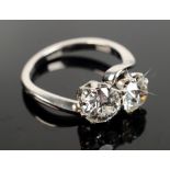A platinum ring crossover set with two diamonds, each is old cut, one measures 0.9ct the other 0.