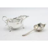 A silver tea strainer, together with a silver sauce boat, 4.8oz.