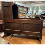 A 18th century oak cradle with panelled back and sides, height 88.