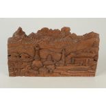 A carved wood panel, depicting an eastern landscape and river scene, height 19cm, width 32.