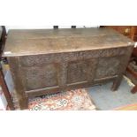 A 17th century carved oak coffer, with a carved frieze and triple panel front on stile feet,