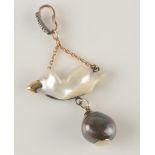 A natural baroque white and black pearl bird form pendant with a gold beak and diamond eye hanging