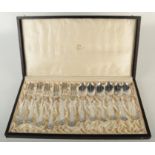 A set of twelve Norwegian silver dessert forks and spoons, with ornate scrolling finials,