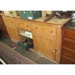 A pine dresser, with three frieze drawers above two cupboard doors, height 102.5cm, width 223cm.