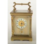 A French late 19th century small carriage alarm clock, the gilt brass case with column corners,