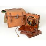 A mahogany plate camera, early 20th century, including stand, with accessories, in a leather case.