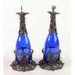 A pair of reproduction early Victorian blue glass decanters each with ornate silver plated mounts,