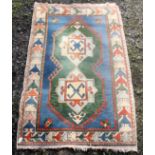 A Turkish rug, of caucasian design, the blue ground with two hooked central medallions,