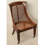 A Regency mahogany bergere library chair, with cane back and seat,