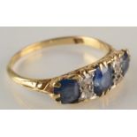 An 18ct gold Victorian style ring set three sapphires and four diamonds.