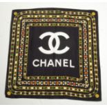 A Chanel silk scarf, black and white with necklace design in gold, red and green, 85 x 85cm.