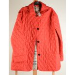 A Burberry red quilted women`s jacket, size large.