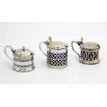 Three early 20th century pierced silver mustard pots, 3.6oz, each with blue glass liner.
