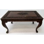 An Anglo Indian carved wood centre table, decorated with animals, and figures amongst foliage,