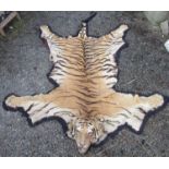 A tiger skin rug, 1930s, taxidermy head with snarling expression, inset glass eyes,