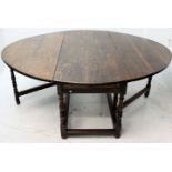 An oak gateleg dining table, the oval top above opposing frieze drawers,