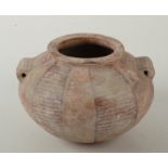 A pre-dynastic Egyptian vessel of compressed spherical shape with everted rim and twin tunnel