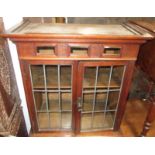 An early 20th century oak hanging cabinet, with a pair of lead lined glazed doors, height 70cm,