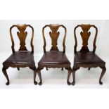 A set of three George II style walnut dining chairs, each with a solid vase shaped splat,