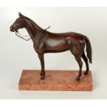 A bronze model of a horse, on a rectangular marble plinth, height 25.5cm, width 24cm, depth 9cm.