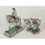 Two continental Faience figures, one of a man on horseback, the other a milk maid seated by a cow.