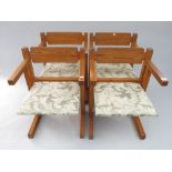 A set of four pine armchairs, each with a padded seat.