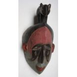 An African wooden Igbo tribal polychrome spirit mask, Nigeria, height 37cm width 18cm.