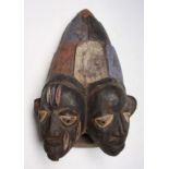 An African wooden Yoruba tribal Gelede two-headed mask, Nigeria, height 36cm width 20cm.