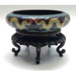 A Chinese cloisonne bowl, circa 1900, height 7cm, diameter 25cm, and a wooden stand.