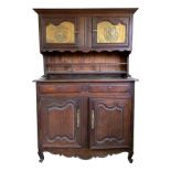 A French oak dresser, the upper cupboard doors set with brass plaques,