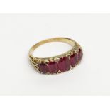 A Victorian high purity gold ring with five graduated rubies and small diamonds in a chased setting.