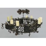 A continental black painted iron chandelier, with ornate scrolls and dragon mounts, width 70cm.