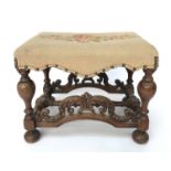 A William and Mary style walnut stool, circa 1900, with a floral decorated needlepoint top,