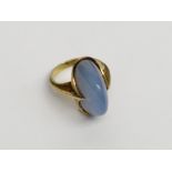 A stylish 1970s gold ring set with an arched blue polished chrysoprase,