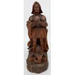 An Austrian carved fruitwood figure of St George, standing in armour, with the dragon at his feet,