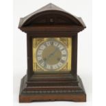 A German oak cased mantel clock, with arched moulded top, brass face,