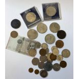 A small selection of coins and an Italian banknote.